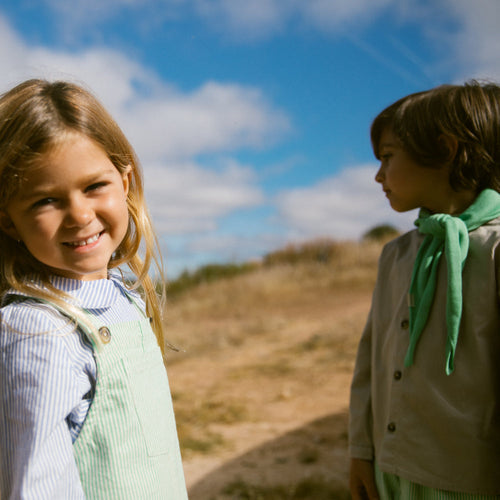 To børn udendørs i sommertøj på en solrig dag