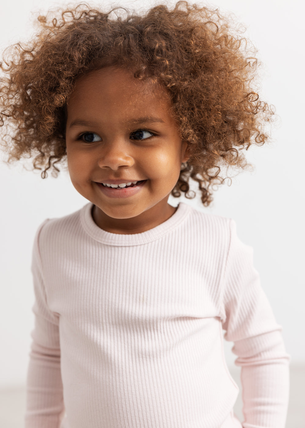 Pink baby T‑shirt with round neck and ribbed hem.