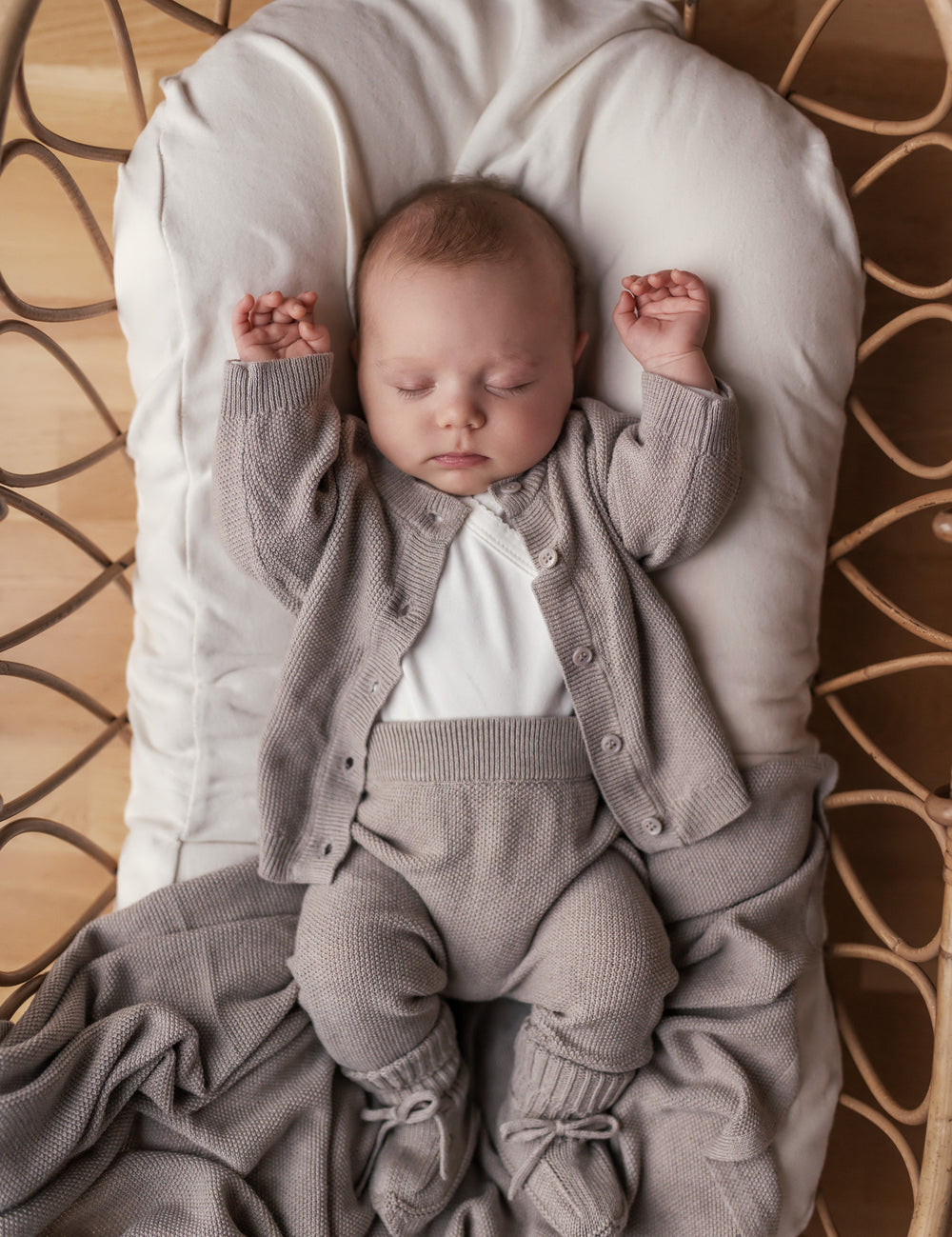 Baby iført grå strik babytøj