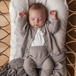 Baby iført grå strik babytøj