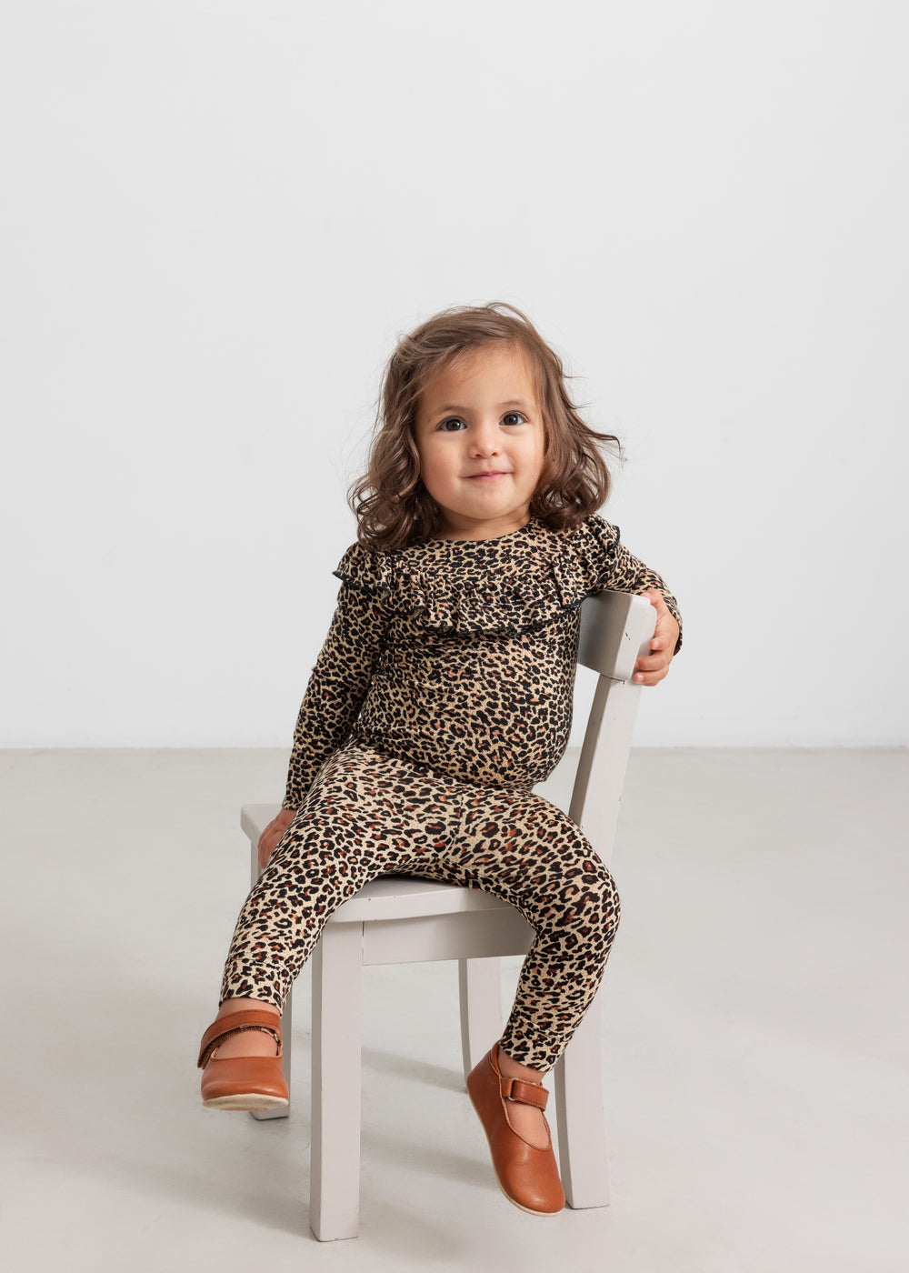 Lille pige i leopard leggings og body med flæse