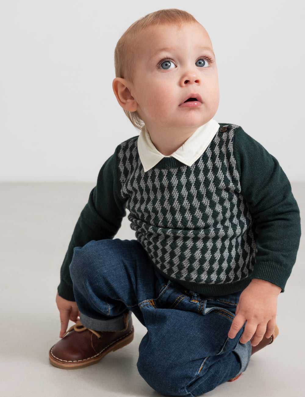Baby wearing dark green checkered knit blouse with shirt collar and jeans