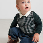 Baby iført mørkegrøn ternet strikbluse med skjortekrave og jeans