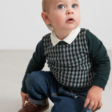 Baby iført mørkegrøn ternet strikbluse med skjortekrave og jeans