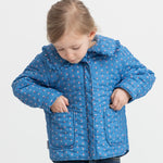 Child wearing a blue thermal jacket with floral print, collar, and pockets.