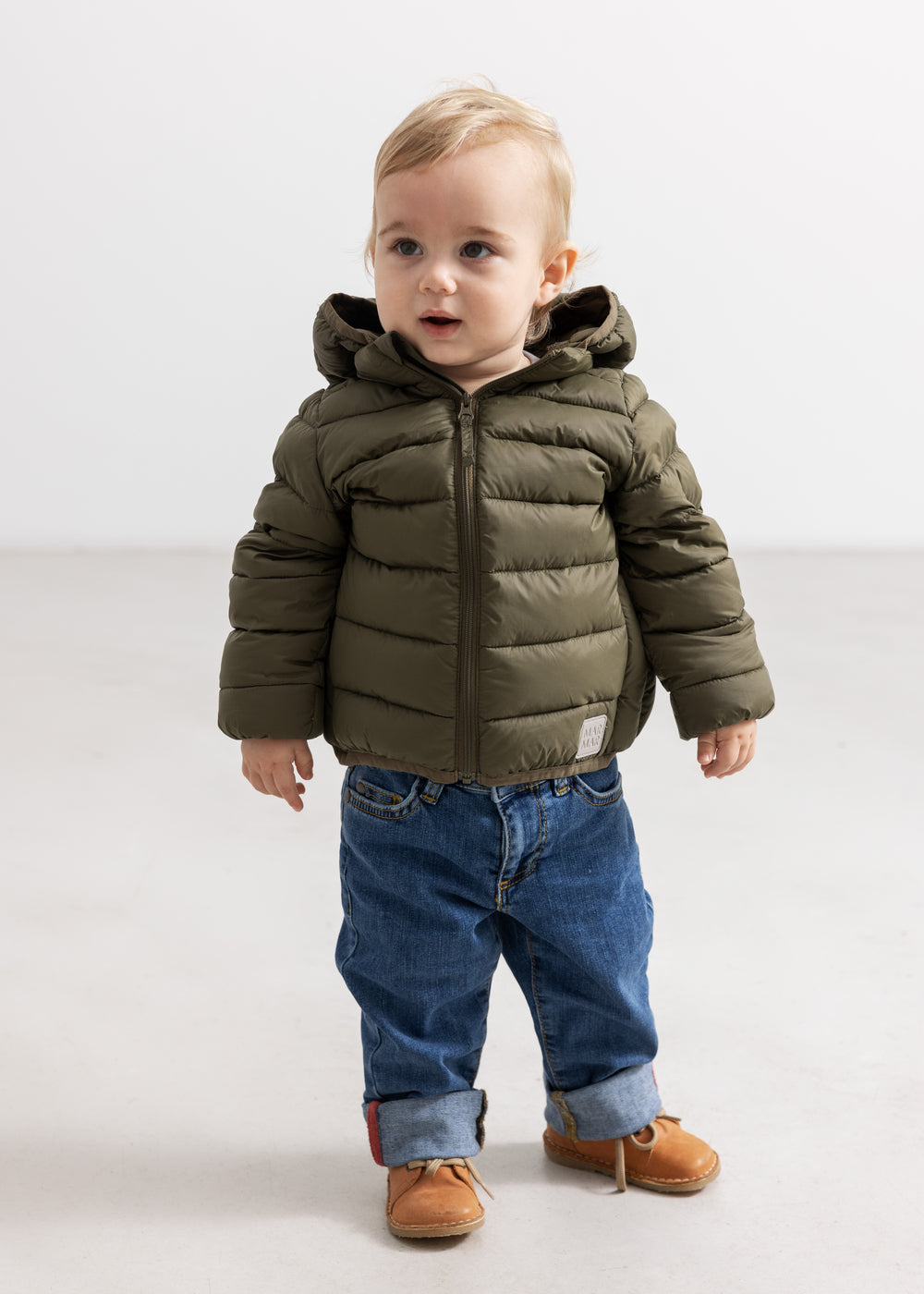 Dark blue denim jeans for children with rolled cuffs and visible pockets.