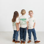 Three children wearing T-shirts with green Moomin print.