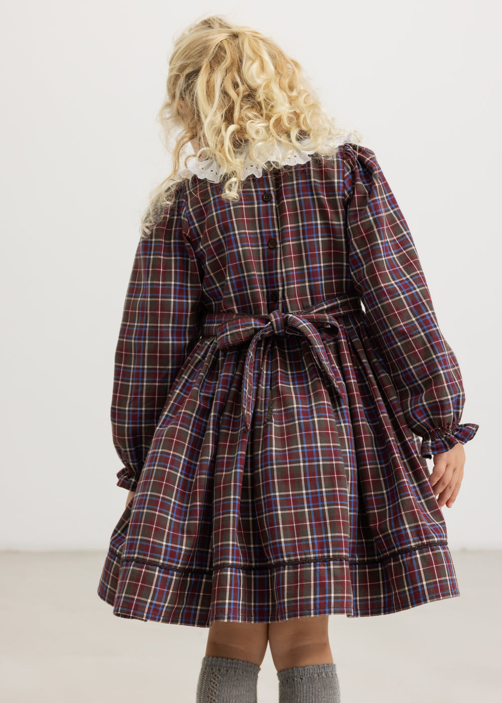 Dark checkered dress set viewed from the back with a bow at the waist and button placket
