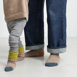 Børn iført uldstriksokker i beige med grøn rib