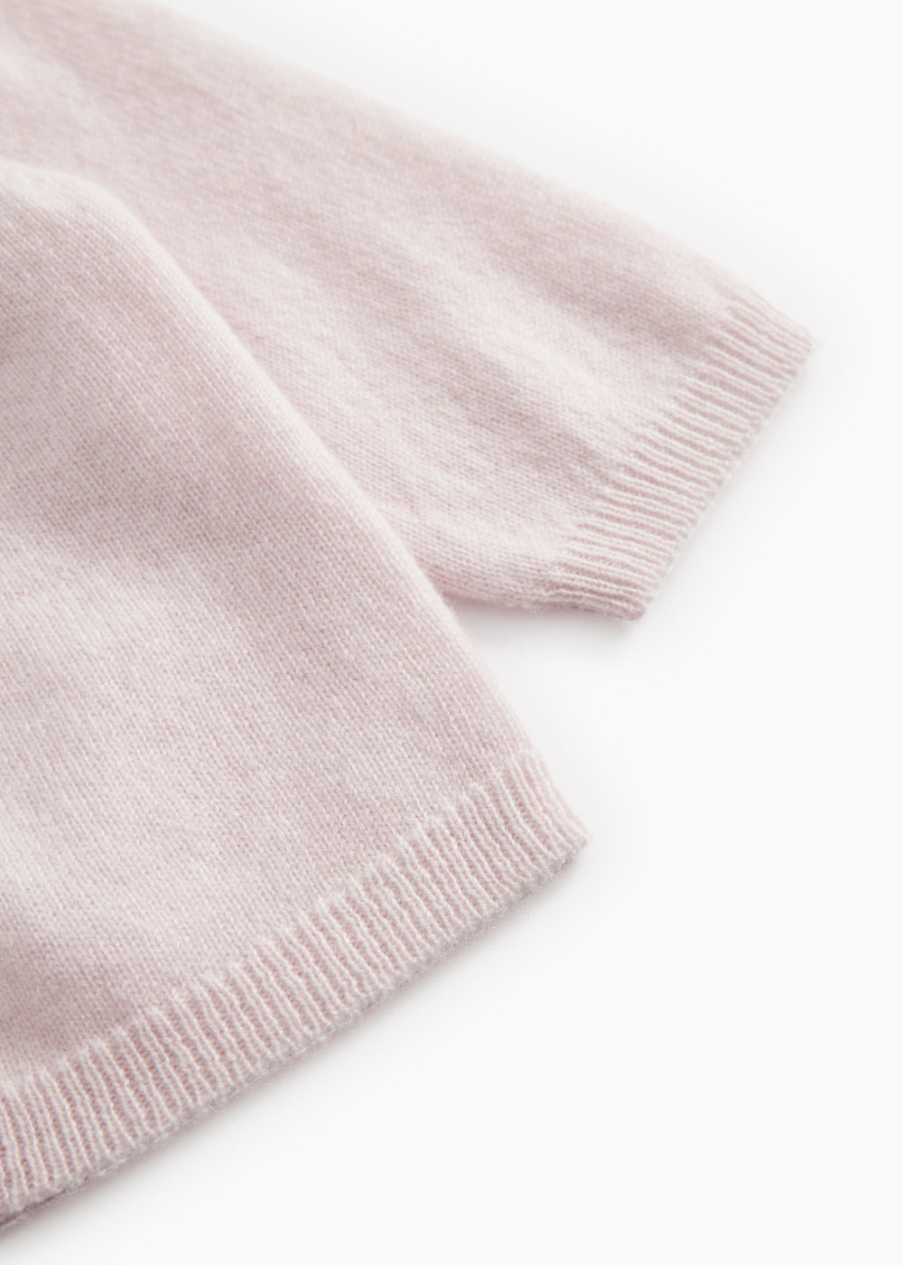 Pink knitted rib edge at the bottom of the cardigan and at the sleeve opening.