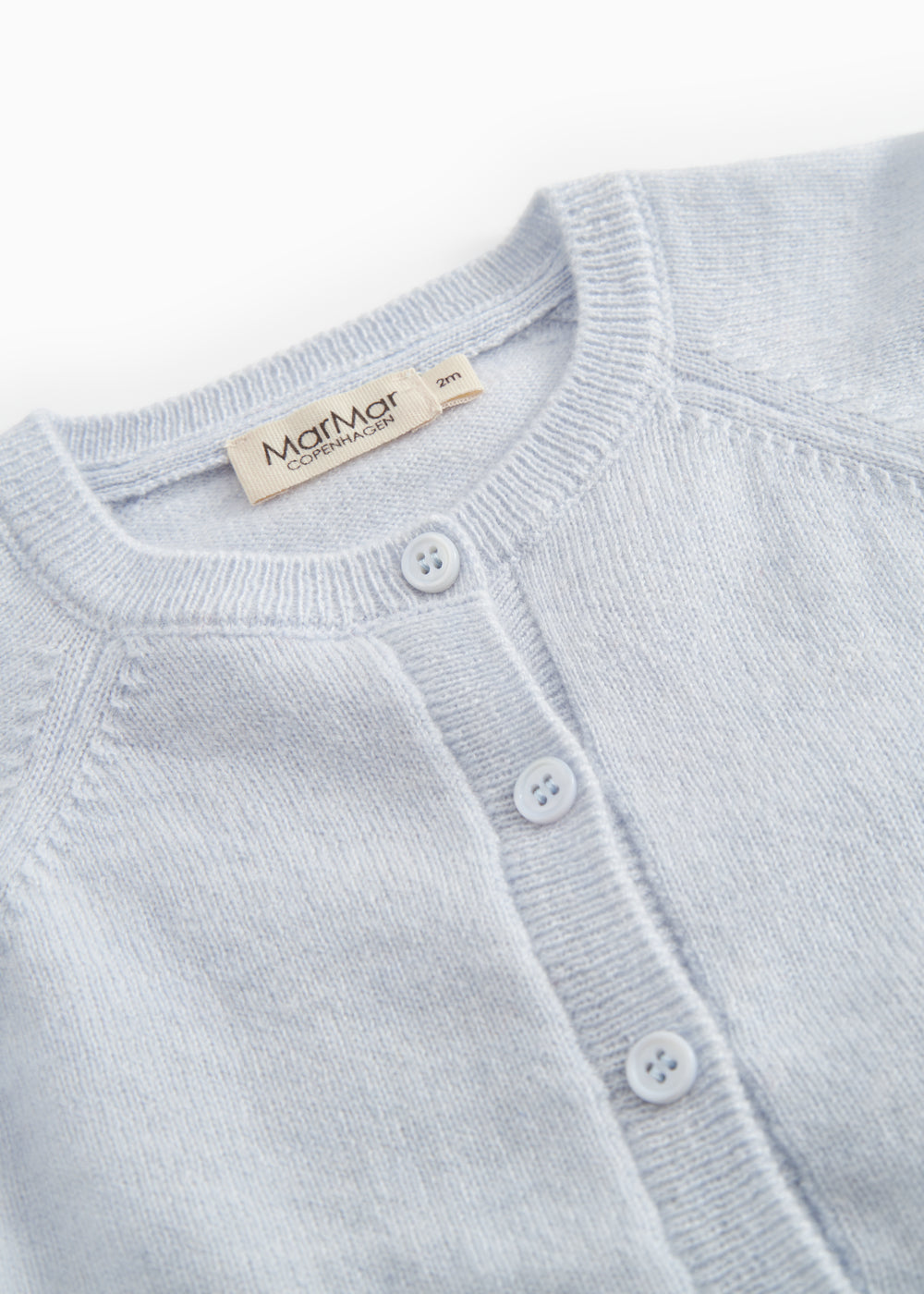 Details of light blue cardigan: round neckline and buttons along the front