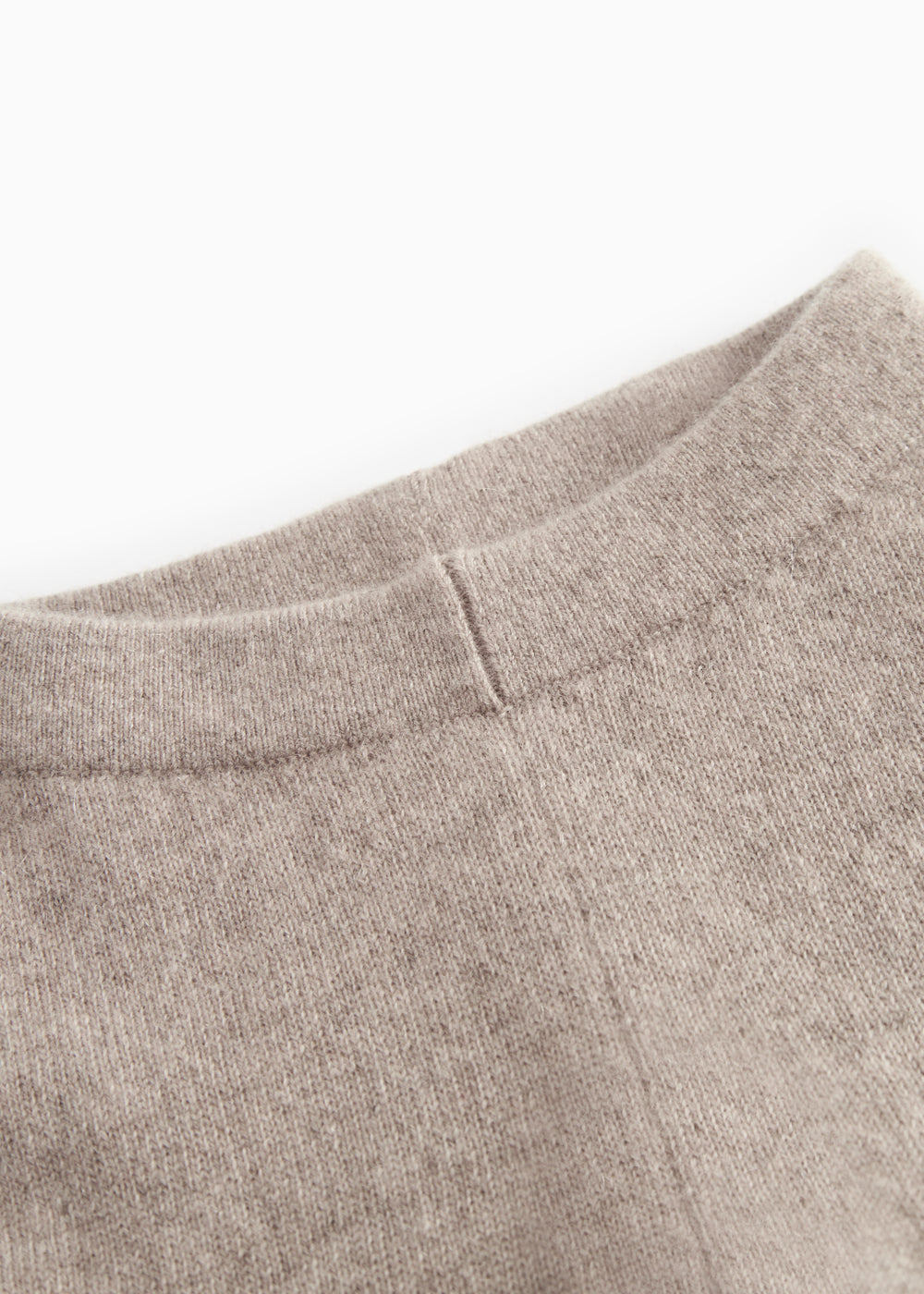 High-rise Kashmir trousers and alpaca melange, close-up of seam and fabric texture in light brown.