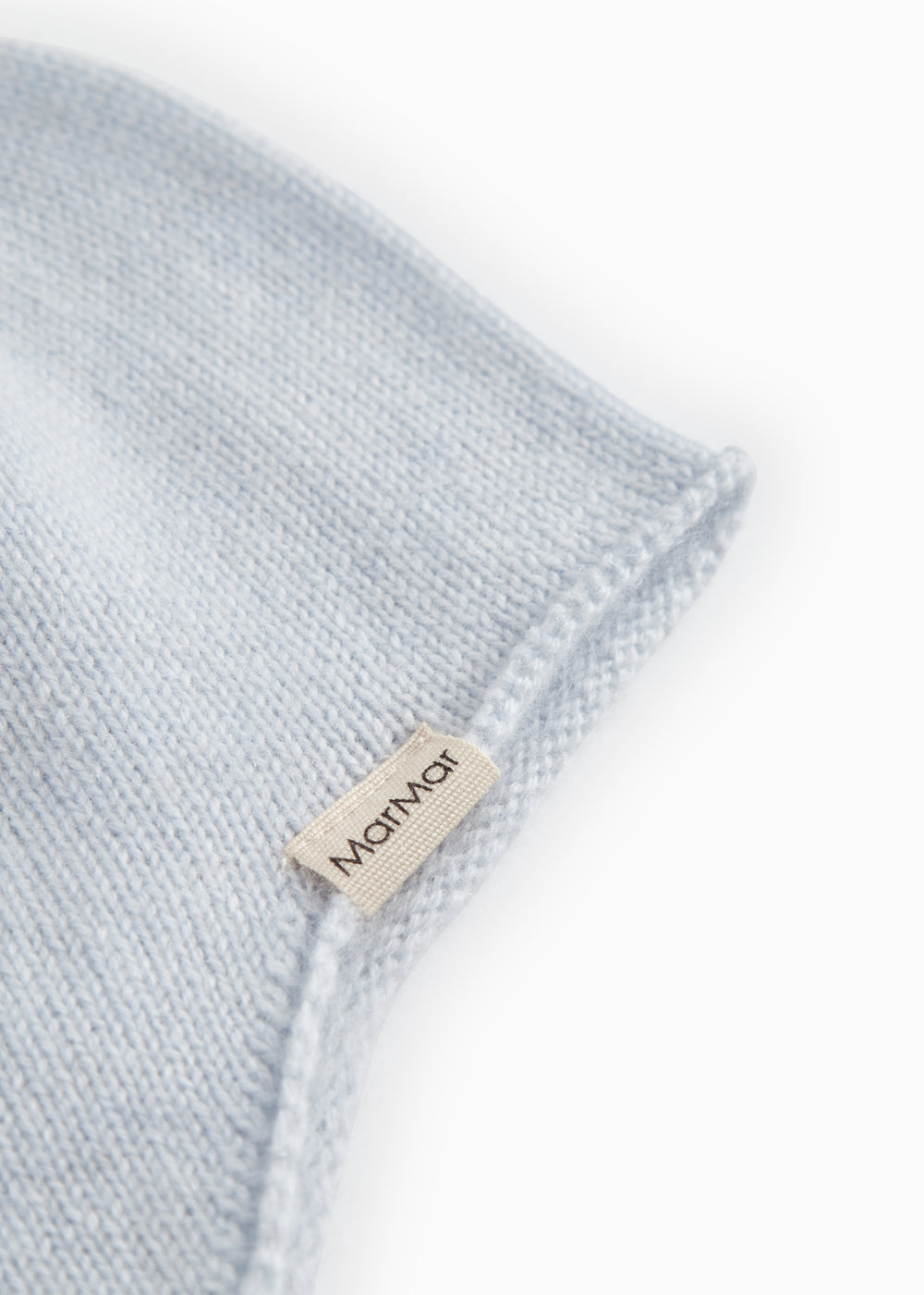 Light blue baby hat in knit with MarMar textile label on the fold edge.