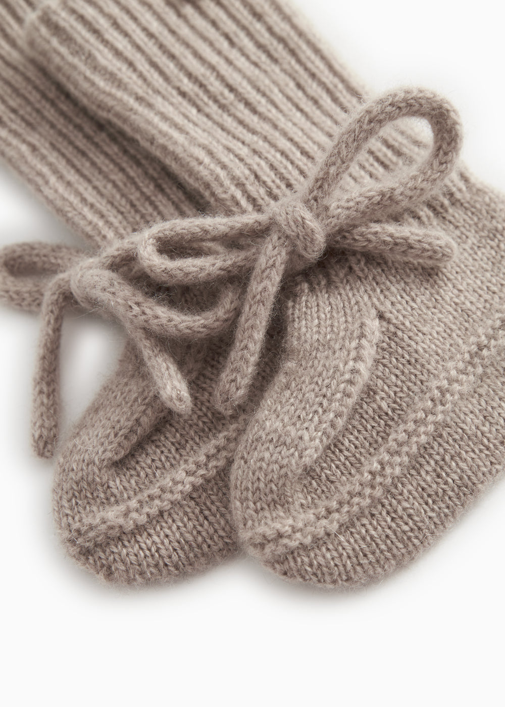 Knitted baby socks in gray-beige mélange with a tied bow at the toe.