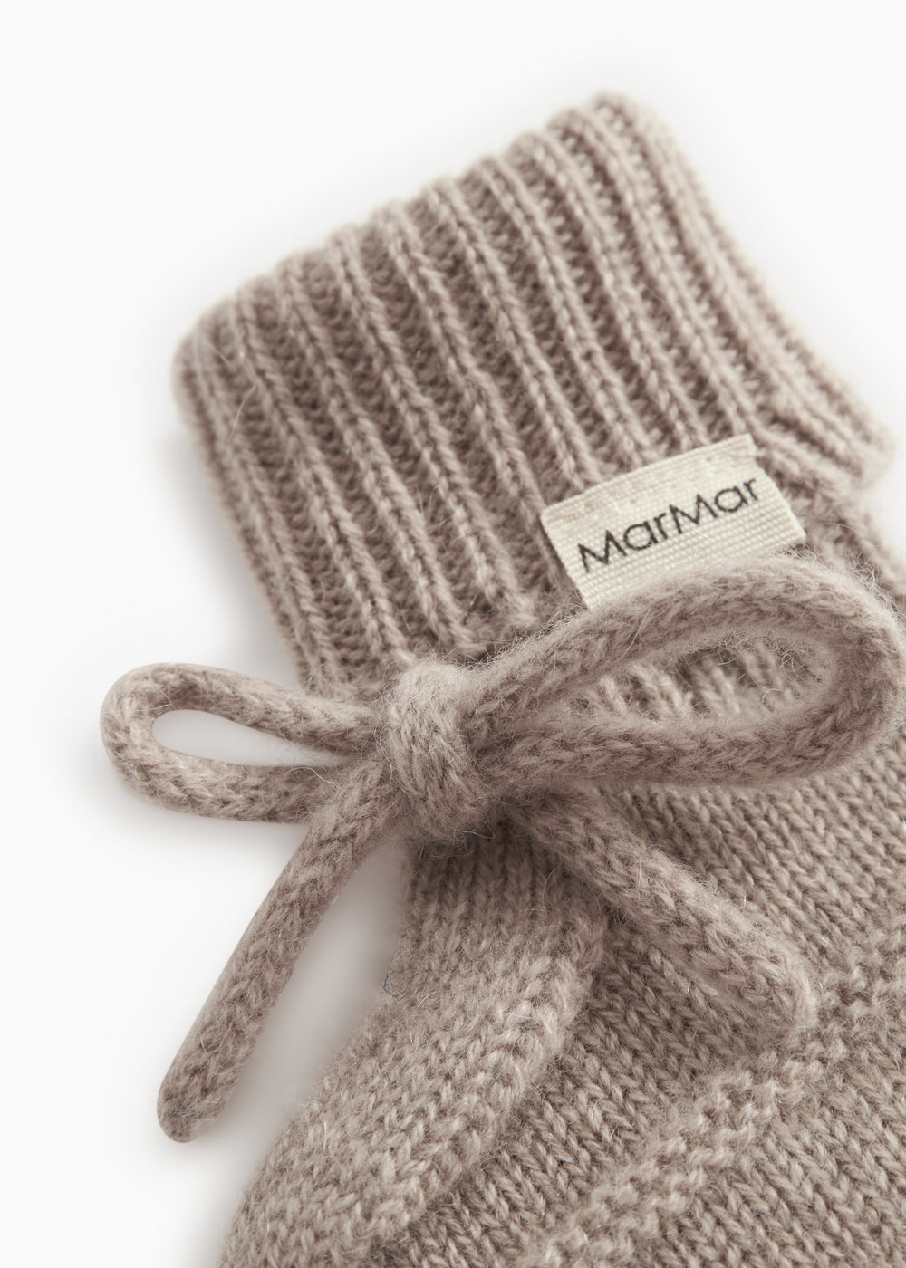 Knitted baby socks in gray-beige blend with ribbed edge and MarMar label, bow in front.