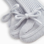 Details of light blue knitted baby shoe with tied laces.