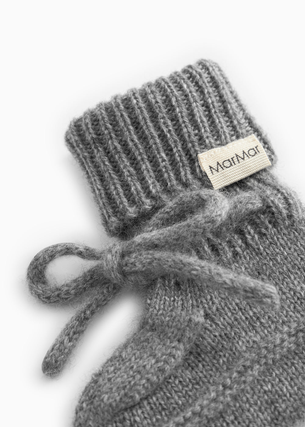 Details of gray knitted baby bootie with MarMar brand and elastic band.