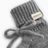 Details of gray knitted baby bootie with MarMar brand and elastic band.