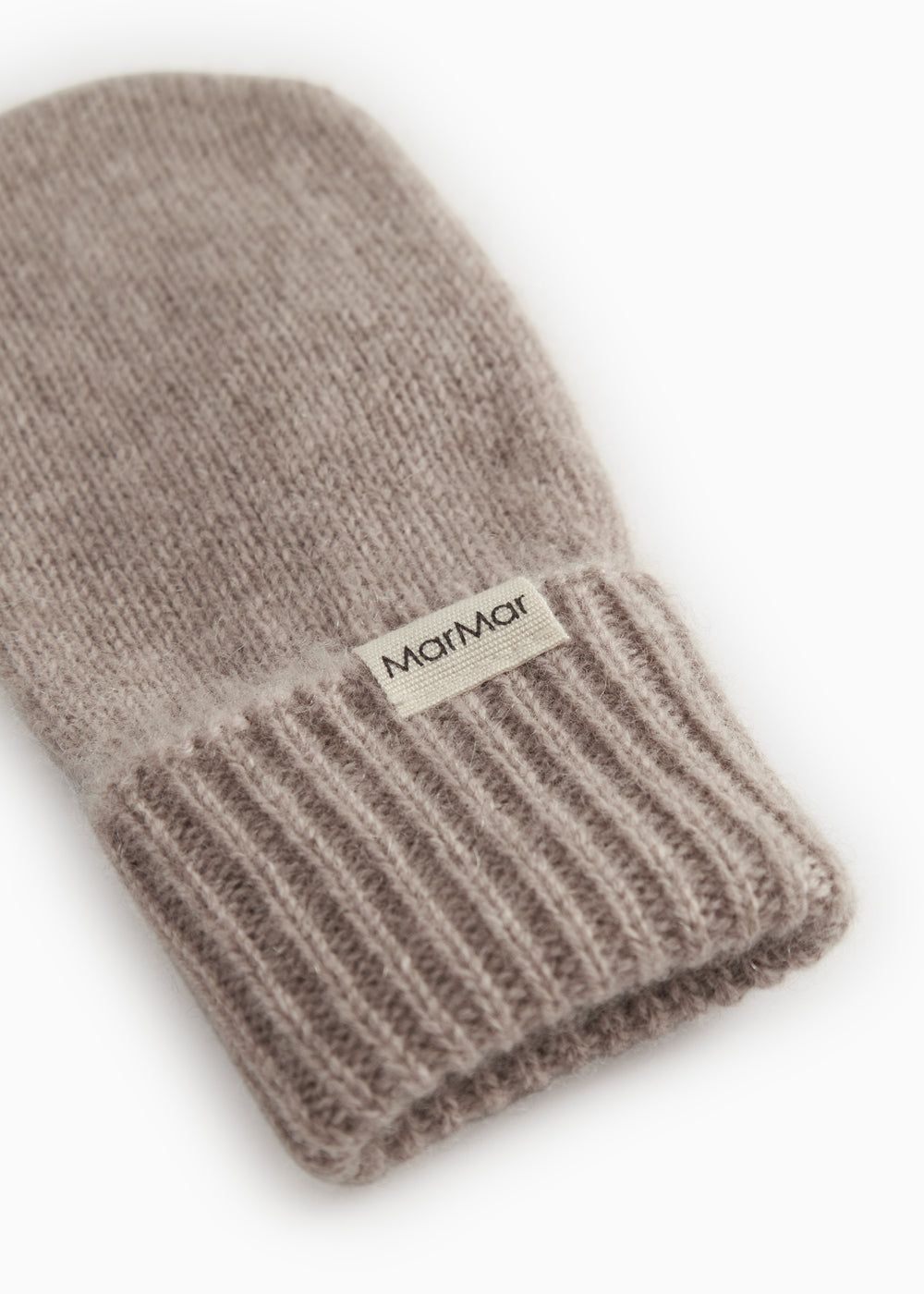Baby-luffe close-up: rib edge at the bottom and label on the knitted wrist.