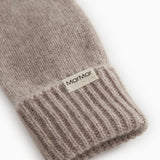 Baby-luffe close-up: rib edge at the bottom and label on the knitted wrist.