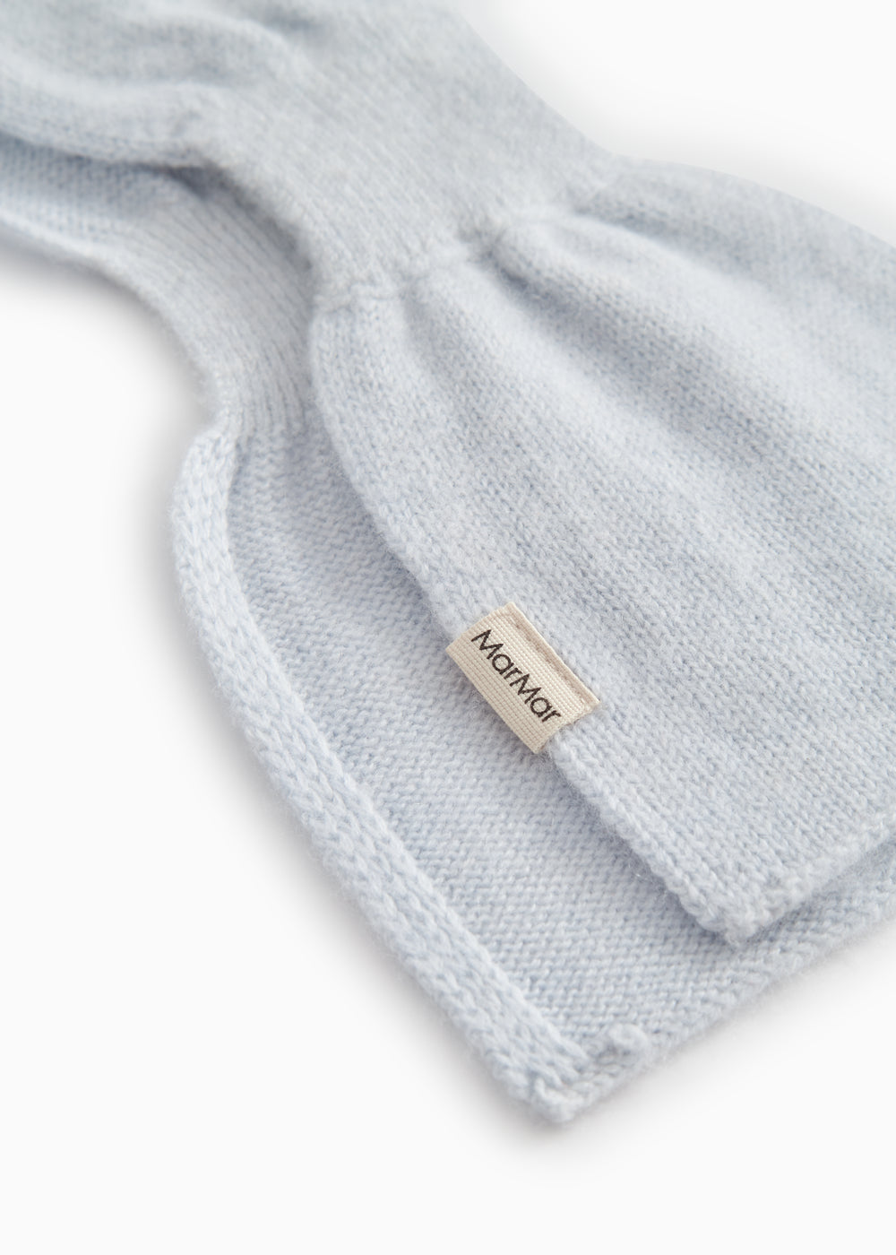 Light blue knitted cashmere scarf with edge stitching and small fabric label.