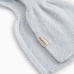 Light blue knitted cashmere scarf with edge stitching and small fabric label.