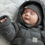 Sovende baby i mørkegrå dundragt med hætte og hue