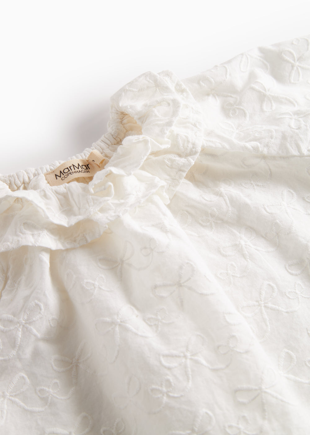 Hvid bluse til børn med flæsekant og broderet mønster