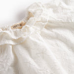 Hvid bluse til børn med flæsekant og broderet mønster