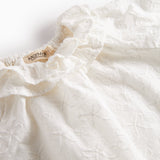 Hvid bluse til børn med flæsekant og broderet mønster