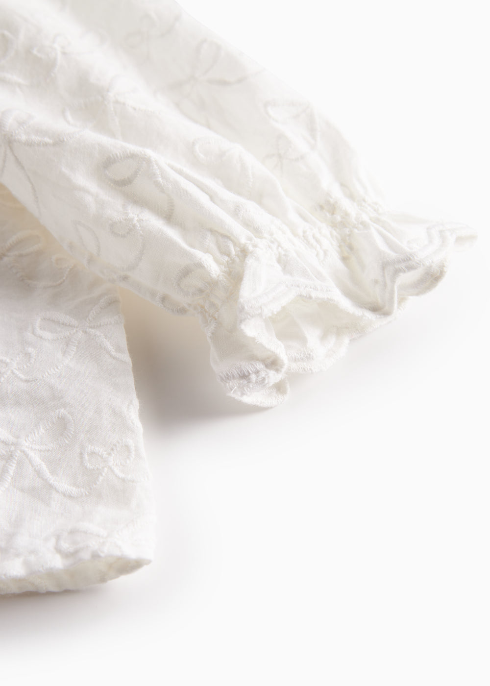 Hvid bluse til børn med flæsekant og broderet mønster