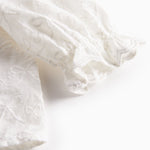 Hvid bluse til børn med flæsekant og broderet mønster