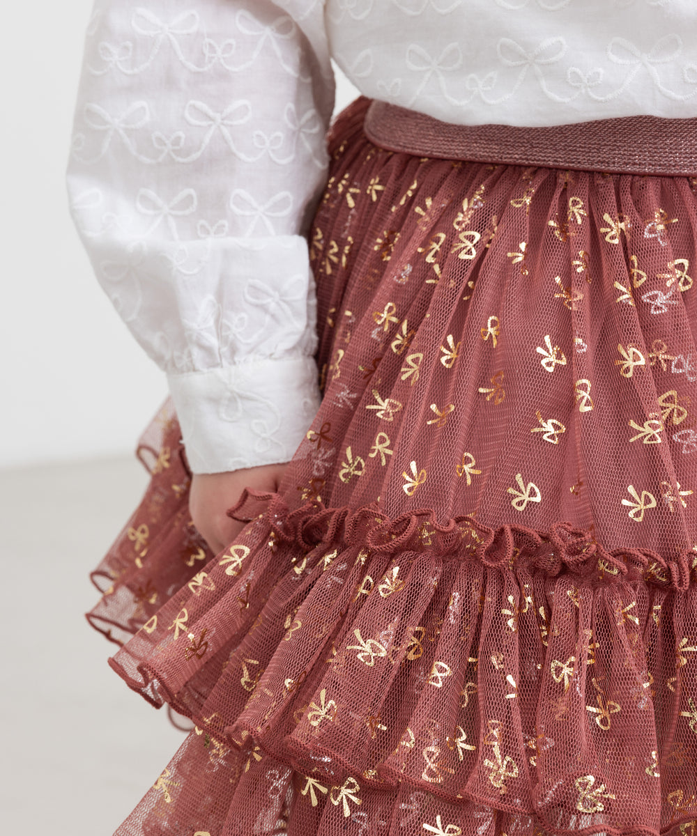 Nærbillede af rosa tylnederdel med flæser og gyldne detaljer til børn