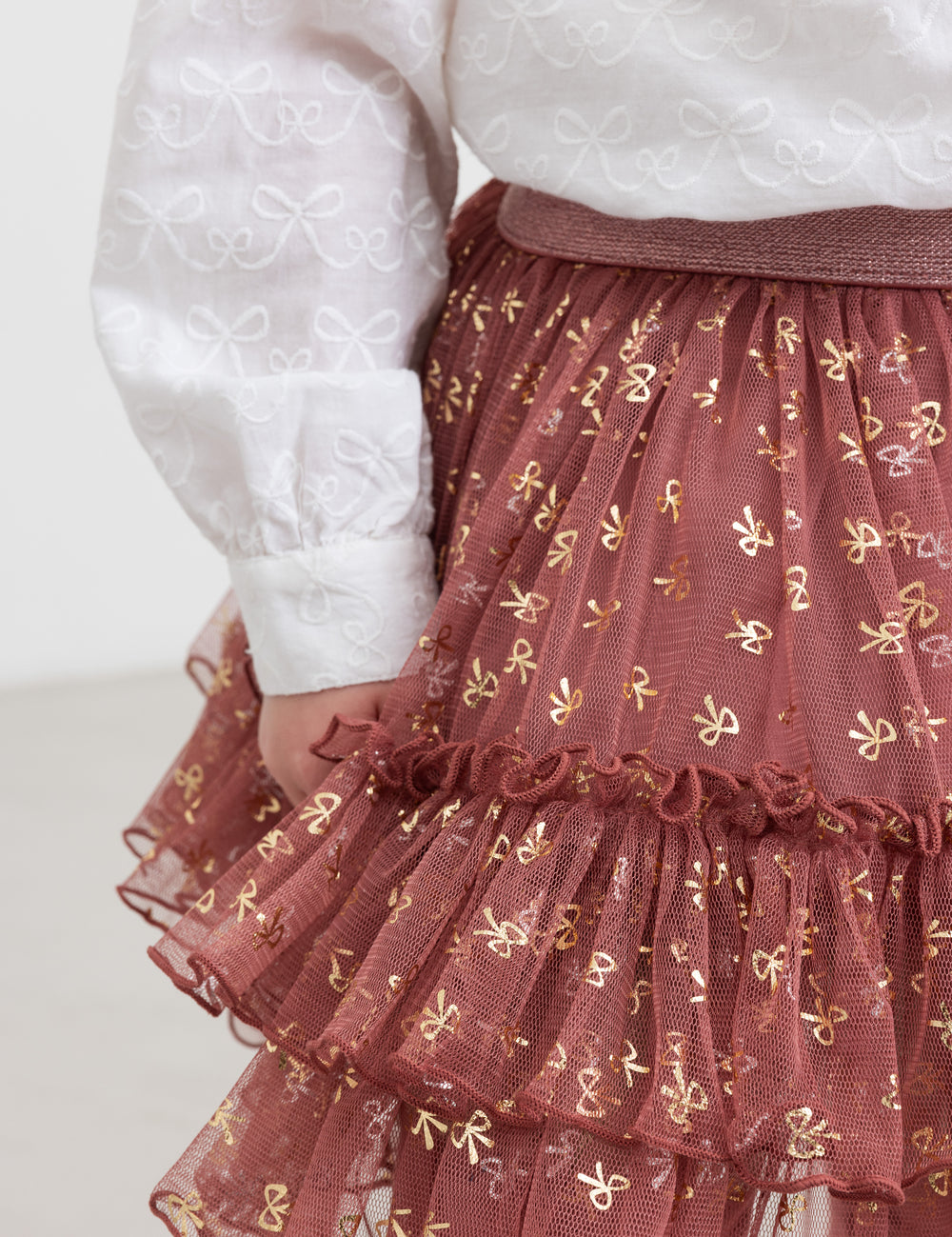 Nærbillede af rosa tylnederdel med flæser og gyldne detaljer til børn