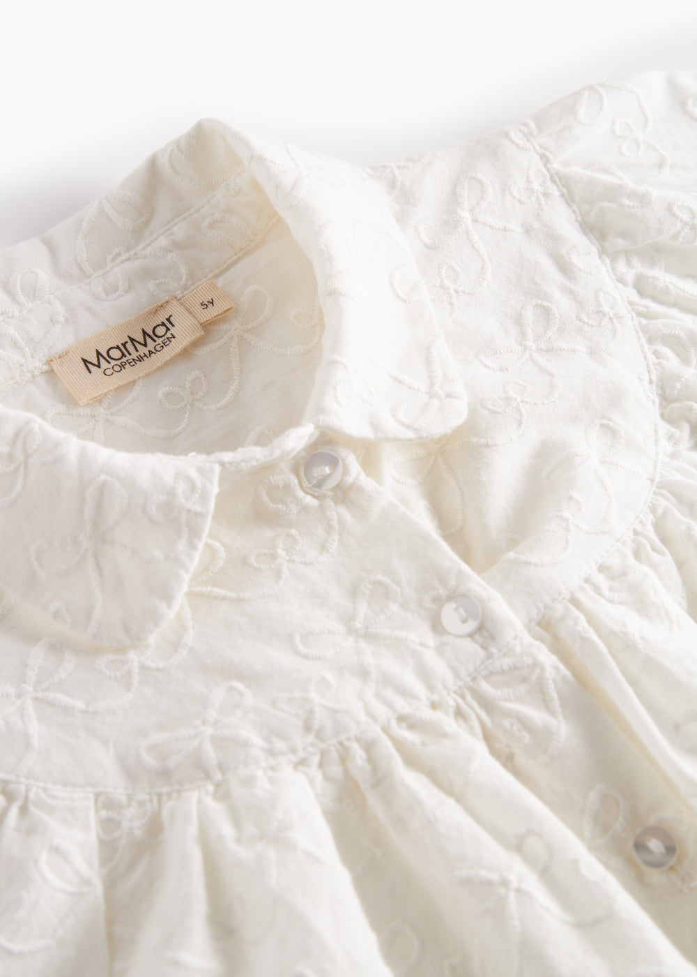 Hvid bluse til børn med broderet mønster og rund krave