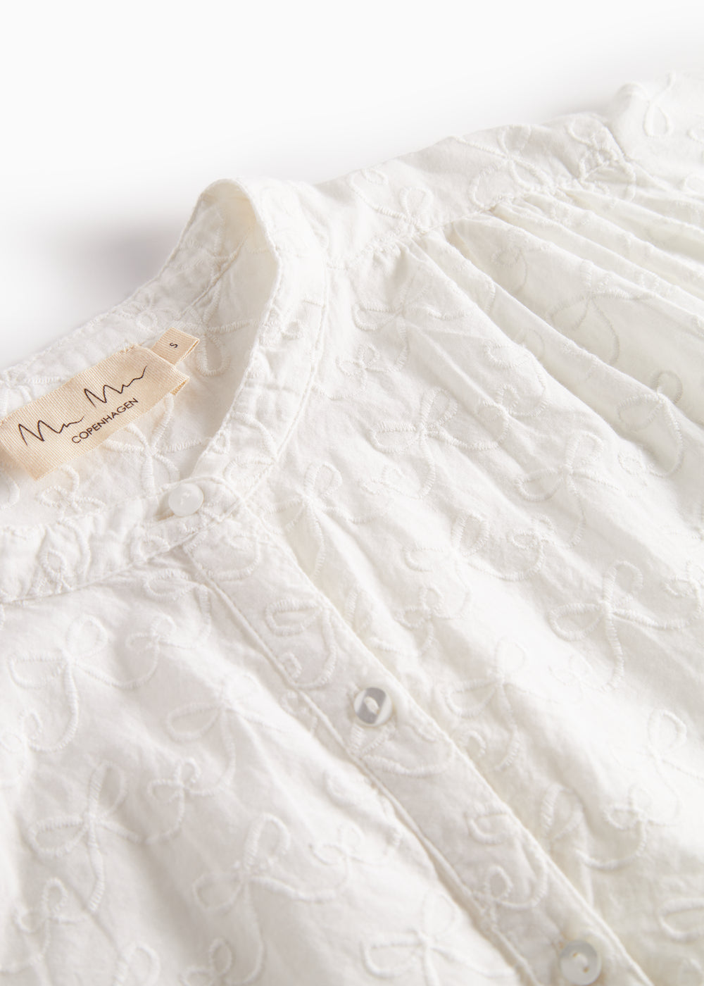 Detalje af blusens broderede mønster på brystet