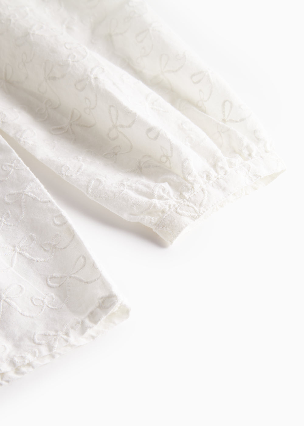 Detalje af blusens lange ærmer med broderede mønstre