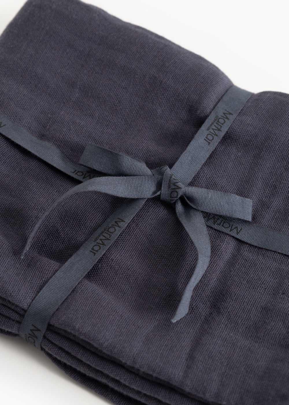 Stiff in dark blue with a strap and visible knot in front.