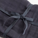 Stiff in dark blue with a strap and visible knot in front.