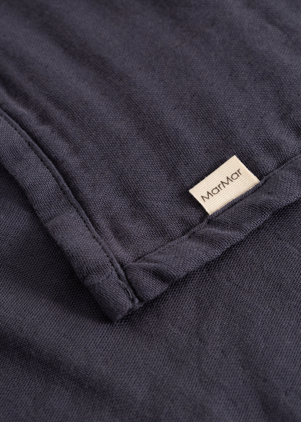 Stainless steel in dark blue with an embroidered label at the folded corner.