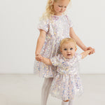 Short-sleeved dress with silver sequins and flowing skirt, round neckline.