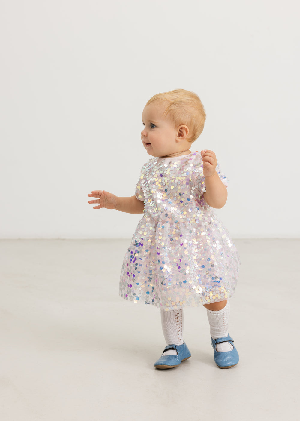 Silver sequin dress on child seen from behind, short sleeves and A-line skirt