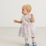 Silver sequin dress on child seen from behind, short sleeves and A-line skirt