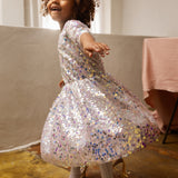 Short-sleeved sparkling dress with silver-colored sequins and a soft, gathered skirt.