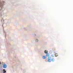 Close-up of a short-sleeved dress with silver glittering sequins and multicolored details.