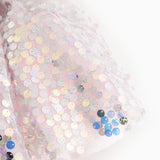 Close-up of a short-sleeved dress with silver glittering sequins and multicolored details.