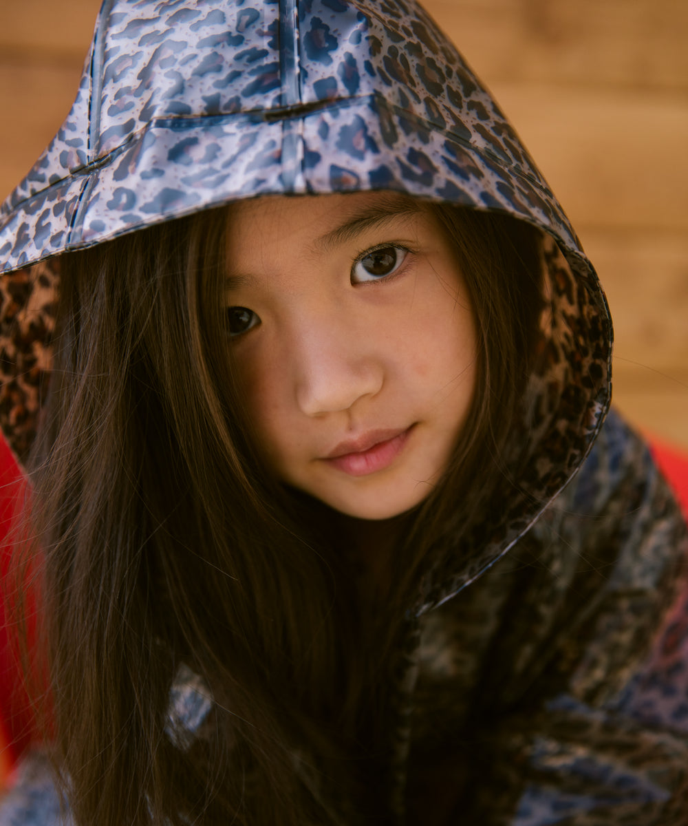 Barn iført leopardmønstret regnjakke me hætte