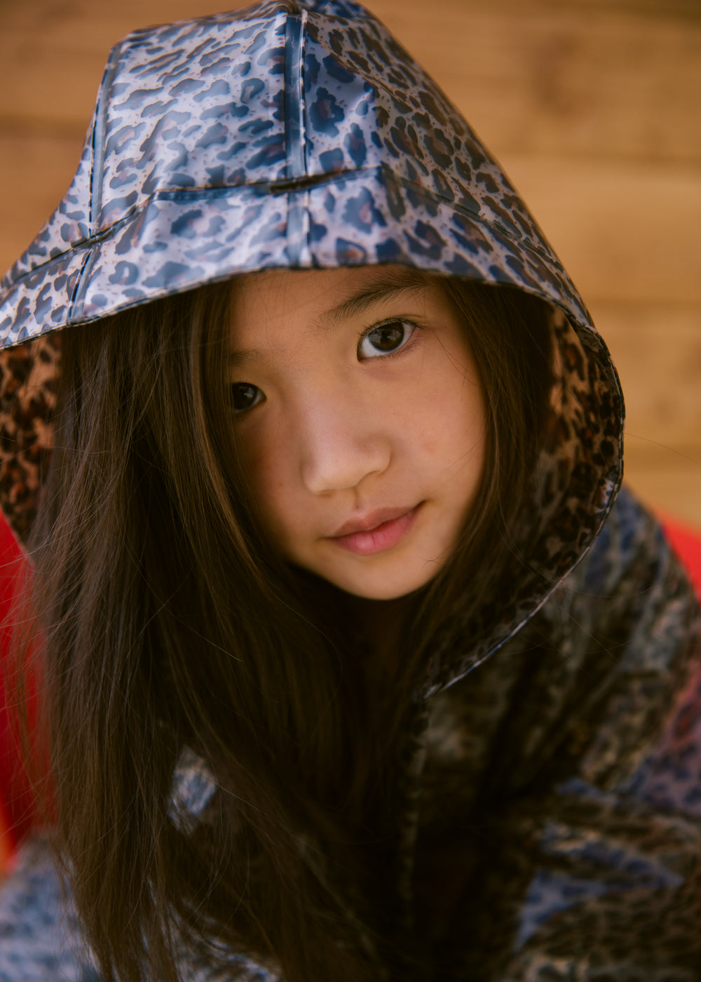 Barn iført leopardmønstret regnjakke me hætte