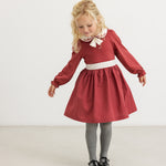 Burgundy dress with white collar and bow tie, gathered skirt and long sleeves.