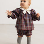 Child wearing chocolate brown checkered bloomers with elastic waistband and short legs